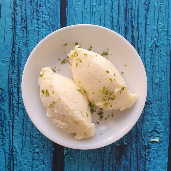 Dos bolas de Puré de Papas en plato blanco sobre madera azul
