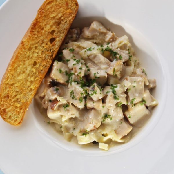 Plato de Fetuccini Alfredo con Pollo y una pieza de pan