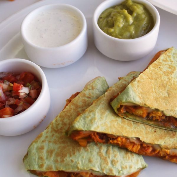 tres quesadillas rellenas de carne con tres salsas