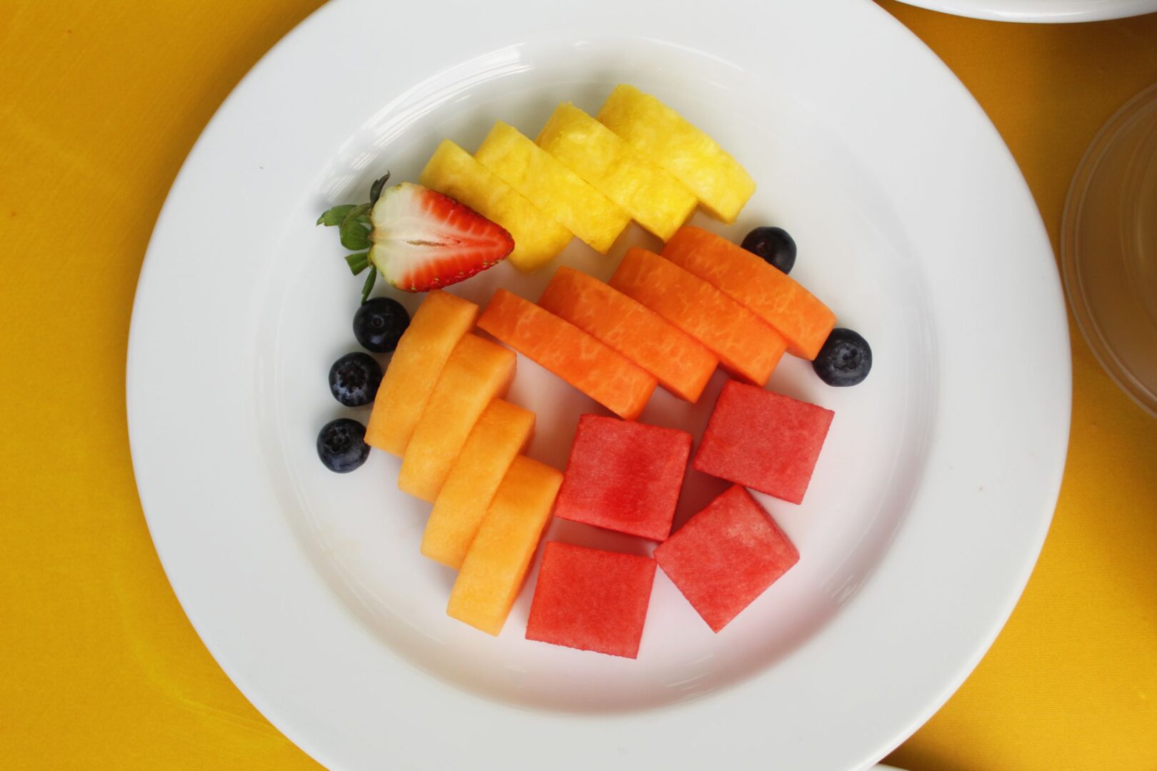 Plato con frutas frescas como sandia, piña, fresa, papaya, melocotón y moras