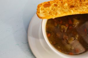 Plato con sopa de lentejas y un pan