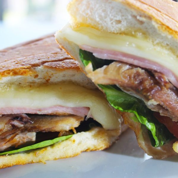 Emparedado cubano con pernil y jamón; acompañado de papas fritas